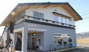 白と灰色の二色の壁の二階建ての建物の写真