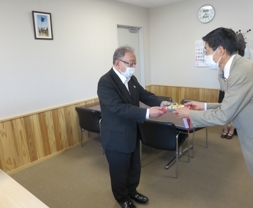 表彰状を受け渡しするスーツを着た男性二人の写真