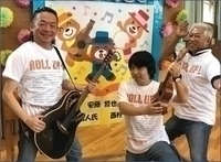 3人の白い服を着た男性がギターなどを持ったりして構えている写真