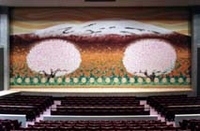桜と富士山の描かれた垂れ幕がかかったステージと複数の客席がある大きなホールの写真