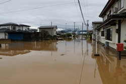 住宅街が道路が見えないほど浸水している写真