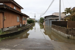 住宅が並ぶ間の道路が浸水している写真