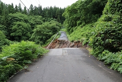 山中の道路が崖のように崩れている写真
