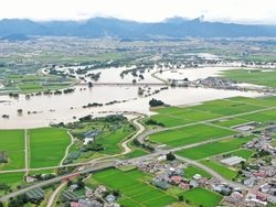 畑や民家の一部が浸水している町の様子を上から写した写真
