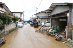 家の間の道路が一面泥水で埋め尽くされている写真