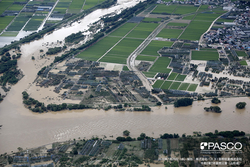 町の一部の住宅街や畑が浸水している様子を上から写した写真