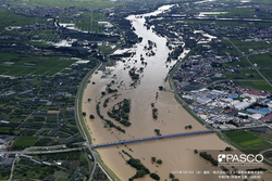 町と町の間の川が氾濫している様子を上から写した写真