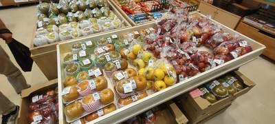 様々な果物が梱包されて棚に置かれている写真
